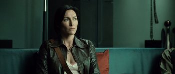 Movie still from “Daybreakers” (2009), directed by Michael Spierig – A woman sitting on a couch looking off to the side; Close Up shot, Over the shoulder angle
