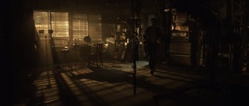 Movie still from “Daybreakers” (2009), directed by Michael Spierig – A man walking through a room with a lot of furniture; Wide shot, High angle