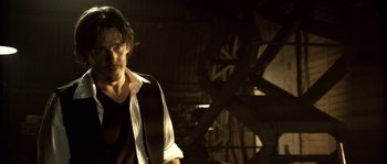 Movie still from “Daybreakers” (2009), directed by Michael Spierig – A man with a guitar in a dark room; Medium shot, Low angle