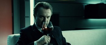 Movie still from “Daybreakers” (2009), directed by Michael Spierig – A man holding a glass of red wine in his right hand; Close Up shot, Low angle
