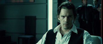 Movie still from “Daybreakers” (2009), directed by Michael Spierig – A person wearing a shirt and vest; Close Up shot, Over the shoulder angle