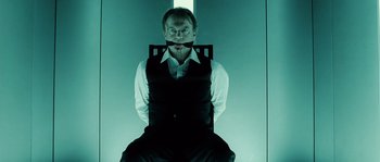 Movie still from “Daybreakers” (2009), directed by Michael Spierig – A man sitting in a chair with a tie around his neck; Medium shot, Low angle