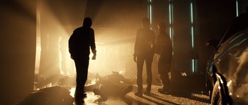 Movie still from “Daybreakers” (2009), directed by Michael Spierig – A group of people standing around a body in a dark room; Wide shot, Low angle
