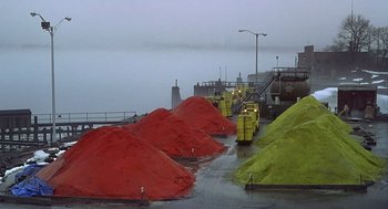Movie still from “Daylight” (1996), directed by Rob Cohen – A bunch of red and yellow sand piles in a harbor; Extreme Wide shot, High angle