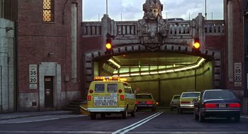 Movie still from “Daylight” (1996), directed by Rob Cohen – A yellow van driving down a street under a bridge; Extreme Wide shot, Low angle