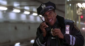 Movie still from “Daylight” (1996), directed by Rob Cohen – A police officer talking on a walkie talkie; Close Up shot, Low angle