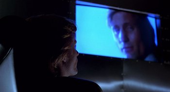 Movie still from “Daylight” (1996), directed by Rob Cohen – A person sitting in front of a television screen; Close Up shot, Over the shoulder angle