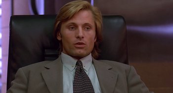 Movie still from “Daylight” (1996), directed by Rob Cohen – A person sitting in a chair wearing a suit; Close Up shot, Low angle