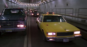 Movie still from “Daylight” (1996), directed by Rob Cohen – A yellow taxi cab driving down a tunnel; Wide shot, High angle
