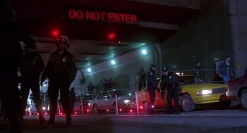 Movie still from “Daylight” (1996), directed by Rob Cohen – A group of police officers standing in front of cars; Wide shot, Low angle