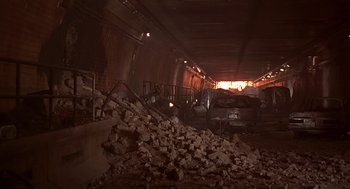 Movie still from “Daylight” (1996), directed by Rob Cohen – A car parked in a tunnel with a pile of rubble in front of it; Extreme Wide shot, High angle
