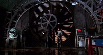 Movie still from “Daylight” (1996), directed by Rob Cohen – A man standing in front of a large metal object; Wide shot, Low angle