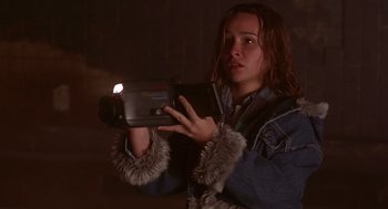 Movie still from “Daylight” (1996), directed by Rob Cohen – A woman holding a video camera in a dark room; Close Up shot, Low angle
