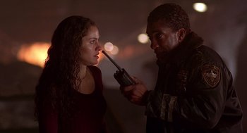 Movie still from “Daylight” (1996), directed by Rob Cohen – A man and a woman looking at each other with a walkie talkie in front of them; Close Up shot, Low angle