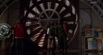Movie still from “Daylight” (1996), directed by Rob Cohen – Two people standing in front of a large metal object; Extreme Wide shot, Low angle