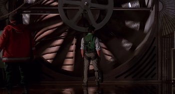 Movie still from “Daylight” (1996), directed by Rob Cohen – A man standing in front of a large metal object; Wide shot, Low angle