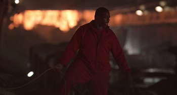 Movie still from “Daylight” (1996), directed by Rob Cohen – A man in a red jacket holding a rope; Medium shot, Low angle
