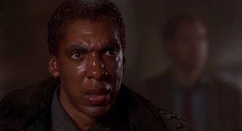 Movie still from “Daylight” (1996), directed by Rob Cohen – A man's face in a dark room; Close Up shot, Low angle