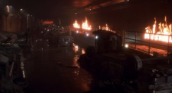 Movie still from “Daylight” (1996), directed by Rob Cohen – A fire is burning in a warehouse on a rainy night; Extreme Wide shot, High angle