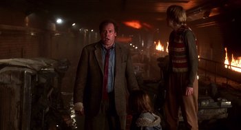 Movie still from “Daylight” (1996), directed by Rob Cohen – A man and two children standing in a dark room; Medium shot, Low angle