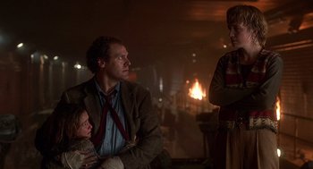 Movie still from “Daylight” (1996), directed by Rob Cohen – A man and a woman standing next to each other in front of a fire; Medium shot, Over the shoulder angle