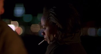 Movie still from “Daylight” (1996), directed by Rob Cohen – A woman is smoking a cigarette in the dark; Close Up shot, Over the shoulder angle