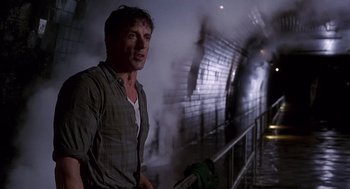Movie still from “Daylight” (1996), directed by Rob Cohen – A man standing next to a fire hydrant in a tunnel; Medium shot, Low angle