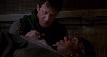 Movie still from “Daylight” (1996), directed by Rob Cohen – A man is shaving another man's face in a room; Close Up shot, High angle