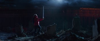 Movie still from “The Kid Who Would Be King” (2019), directed by Joe Cornish – A person holding a sword in a dark place; Wide shot, Low angle