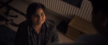 Movie still from “The Kid Who Would Be King” (2019), directed by Joe Cornish – A young boy sitting on the floor in front of a dresser; Close Up shot, High angle