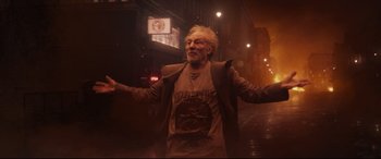 Movie still from “The Kid Who Would Be King” (2019), directed by Joe Cornish – An older man is standing in the street; Medium shot, Low angle