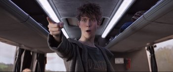 Movie still from “The Kid Who Would Be King” (2019), directed by Joe Cornish – A young man holding something up to the camera; Medium shot, Low angle