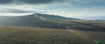 Movie still from “The Kid Who Would Be King” (2019), directed by Joe Cornish – A group of people flying a kite in a grassy field; Extreme Wide shot, High angle