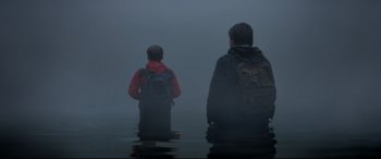 Movie still from “The Kid Who Would Be King” (2019), directed by Joe Cornish – Two people standing in the middle of a body of water; Wide shot, Over the shoulder angle