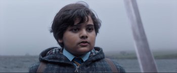 Movie still from “The Kid Who Would Be King” (2019), directed by Joe Cornish – A young boy wearing a jacket and a tie; Close Up shot, Low angle