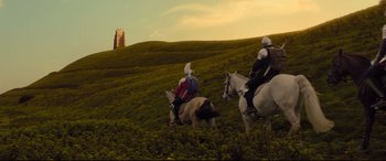 Movie still from “The Kid Who Would Be King” (2019), directed by Joe Cornish – Two men on horseback and a cow in a grassy field; Extreme Wide shot, Low angle