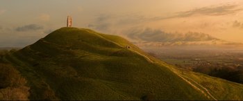 Movie still from “The Kid Who Would Be King” (2019), directed by Joe Cornish – A grassy hill with a couple of people standing on it; Extreme Wide shot, High angle