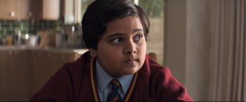 Movie still from “The Kid Who Would Be King” (2019), directed by Joe Cornish – A young boy wearing a sweater and a tie; Close Up shot, Over the shoulder angle