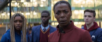 Movie still from “The Kid Who Would Be King” (2019), directed by Joe Cornish – Two men standing next to each other in front of a building; Close Up shot, Low angle