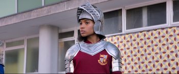 Movie still from “The Kid Who Would Be King” (2019), directed by Joe Cornish – A person wearing a metal helmet and armor; Medium shot, Over the shoulder angle