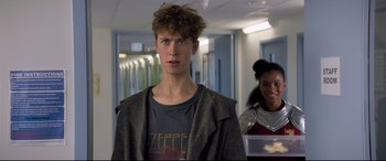 Movie still from “The Kid Who Would Be King” (2019), directed by Joe Cornish – A young man standing next to a woman in a hallway; Medium shot, Over the shoulder angle