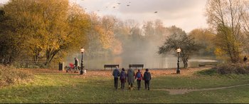 Movie still from “The Kid Who Would Be King” (2019), directed by Joe Cornish – A group of people standing in front of a body of water; Extreme Wide shot, High angle