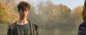 Movie still from “The Kid Who Would Be King” (2019), directed by Joe Cornish – A young man standing next to a body of water; Close Up shot, Over the shoulder angle
