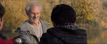 Movie still from “The Kid Who Would Be King” (2019), directed by Joe Cornish – An older man talking to a younger man outside; Close Up shot, Over the shoulder angle