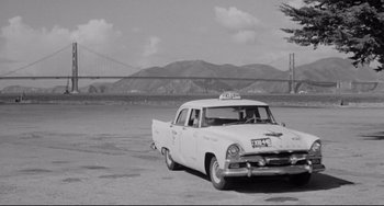 Movie still from “Days of Wine and Roses” (1962), directed by Blake Edwards – An old taxi cab parked in front of the golden gate bridge in black and white; Wide shot, Low angle