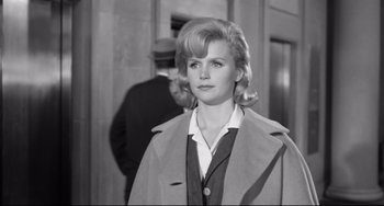 Movie still from “Days of Wine and Roses” (1962), directed by Blake Edwards – A black and white photo of a woman in a trench coat; Medium shot, Low angle