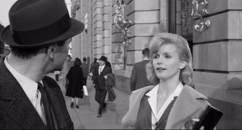 Movie still from “Days of Wine and Roses” (1962), directed by Blake Edwards – An old photo of a woman talking to a man on the sidewalk; Medium shot, Over the shoulder angle