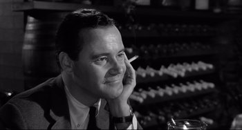 Movie still from “Days of Wine and Roses” (1962), directed by Blake Edwards – A black and white photo of a man smoking a cigarette; Close Up shot, Low angle