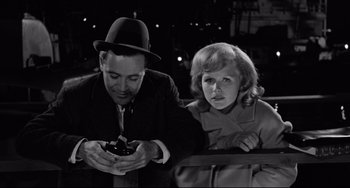 Movie still from “Days of Wine and Roses” (1962), directed by Blake Edwards – A man and a woman looking at a cell phone; Medium shot, High angle