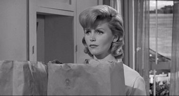 Movie still from “Days of Wine and Roses” (1962), directed by Blake Edwards – A black and white photo of a woman holding a paper bag; Close Up shot, Over the shoulder angle